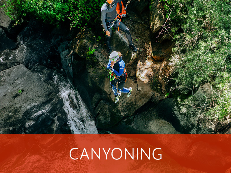 Groupe en canyoning, sautant dans une piscine naturelle au cœur des montagnes.