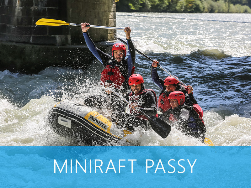 Groupe en mini-raft sur une rivière, défiant les rapides dans un cadre alpin.