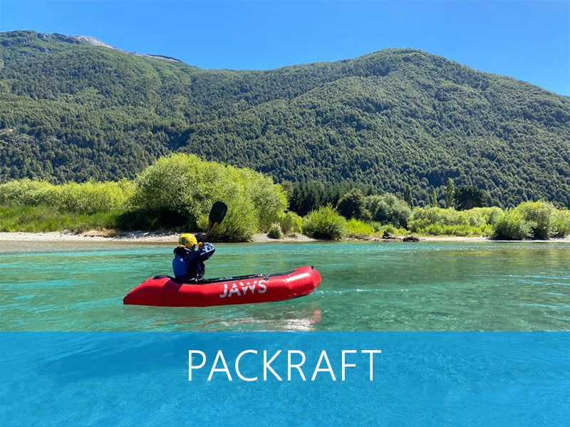 Groupe en packraft descendant une rivière alpine, naviguant entre les rochers
